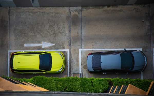 Two cars in parallel parking spots. Photo credit: Pixabay.