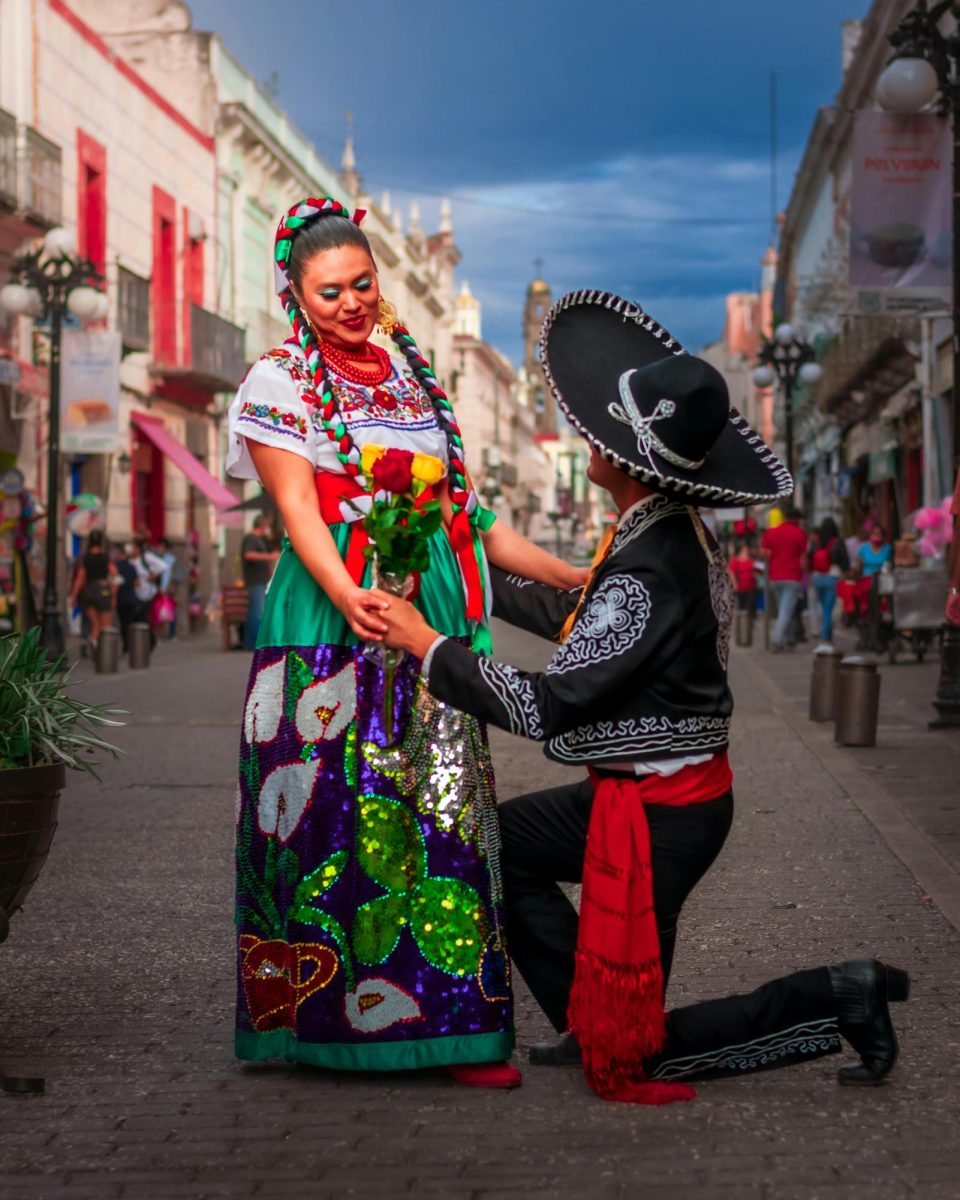 Women with a colorful dress and a man wearing a Charro suit. 